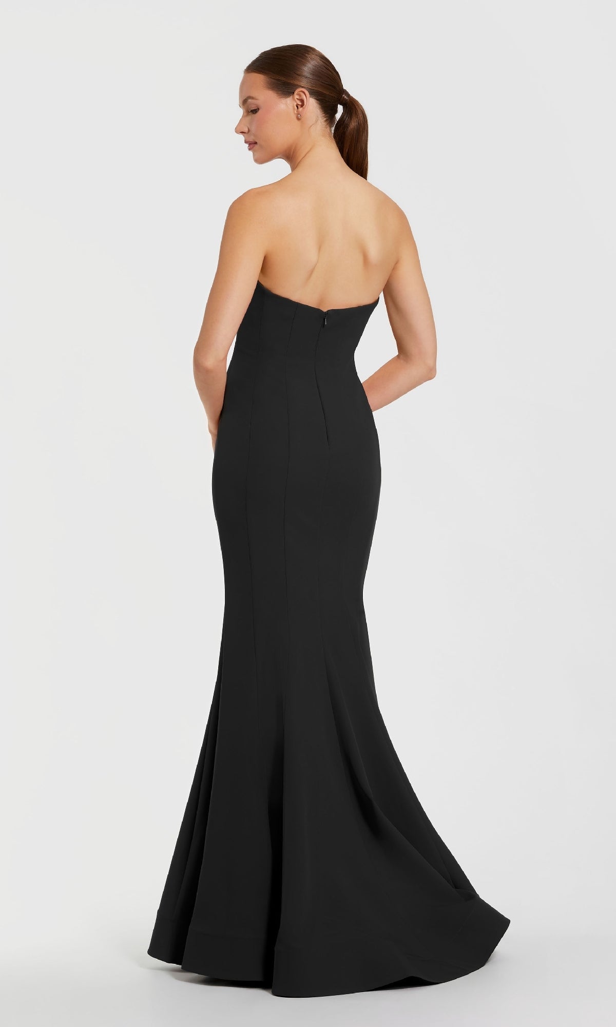 A woman stands with her back to the camera in a Mac Duggal 2300 Strapless Long Black Formal Dress against a plain white background.